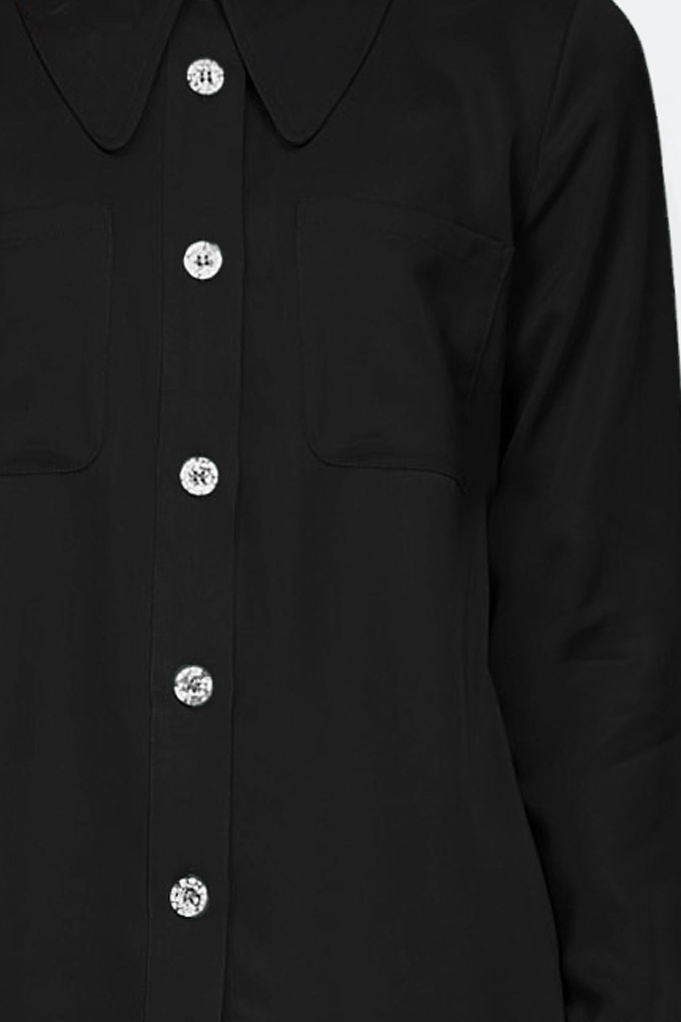Woman wearing a long sleeve black shirt with white buttons