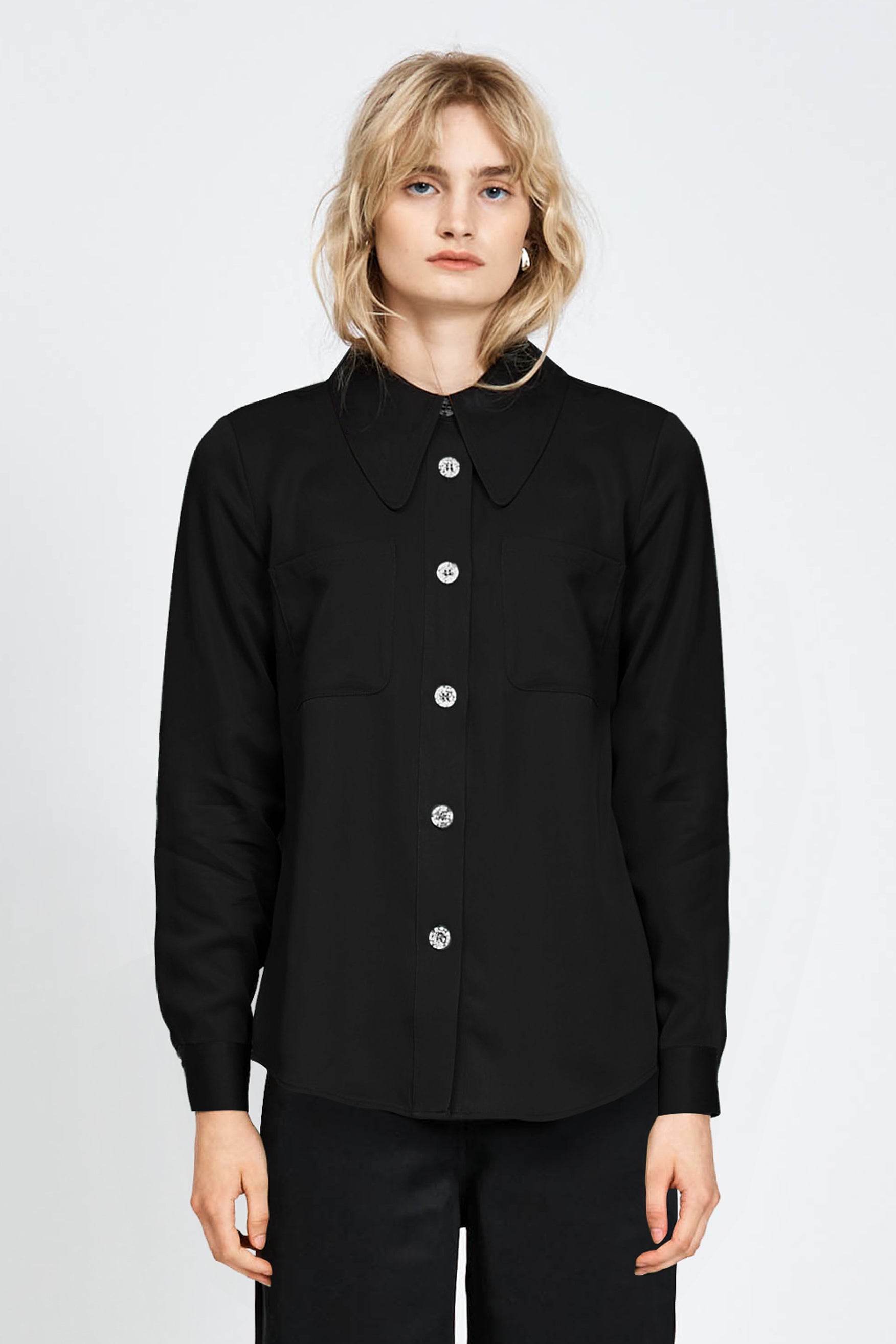 Woman wearing a long sleeve black shirt with white buttons