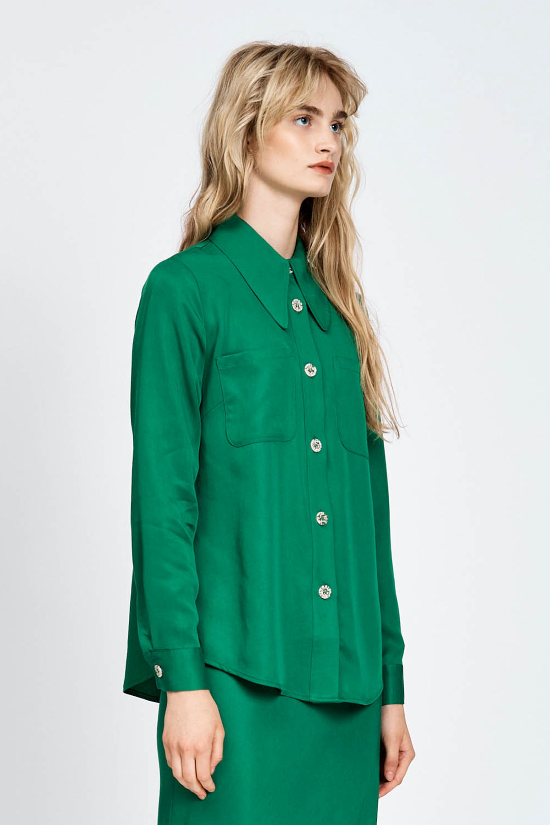 Woman wearing a green long sleeve shirt with white buttons