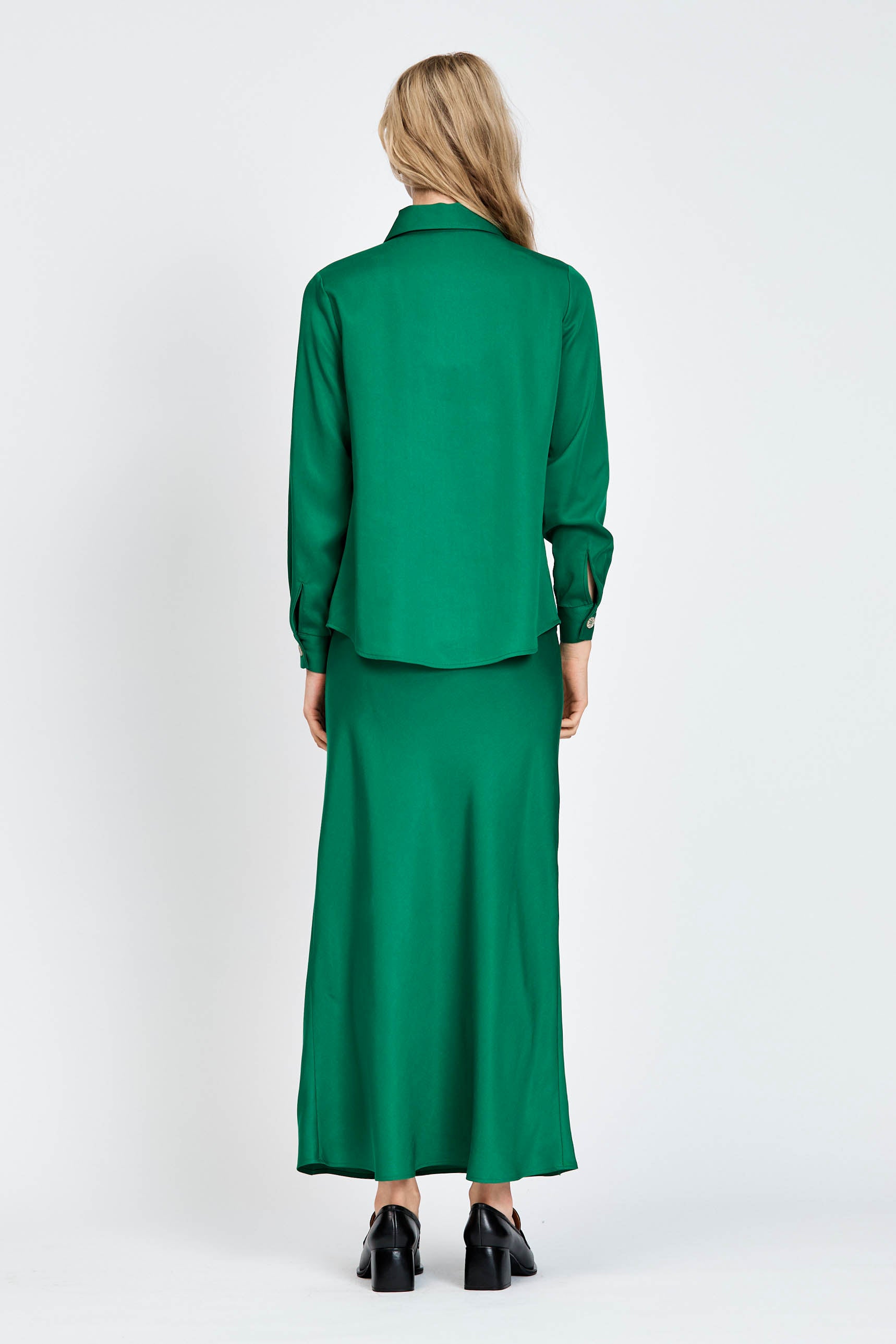 Woman wearing a green long sleeve shirt with white buttons