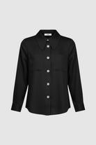 Woman wearing a long sleeve black shirt with white buttons