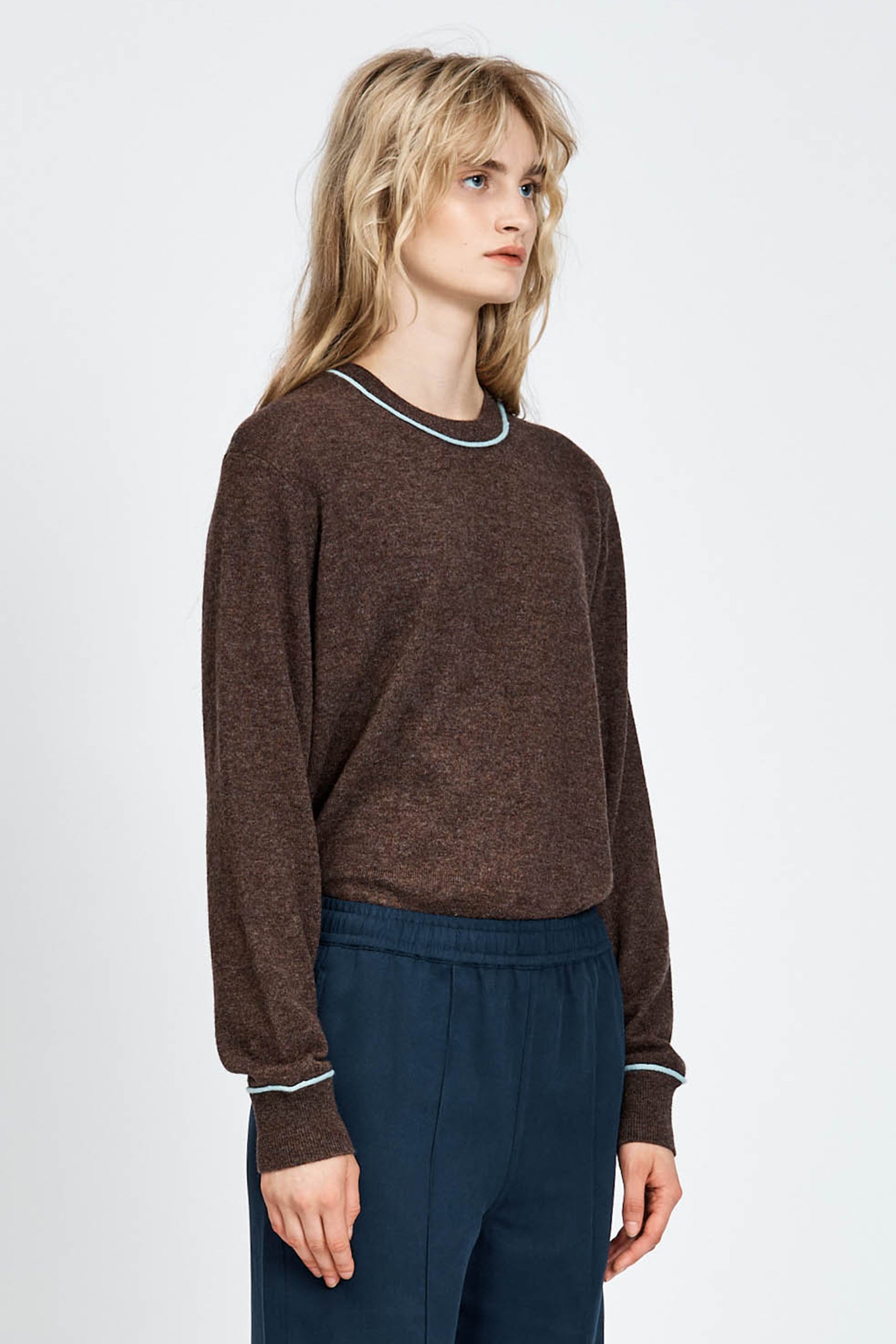 Woman wearing a brown long sleeve jumper