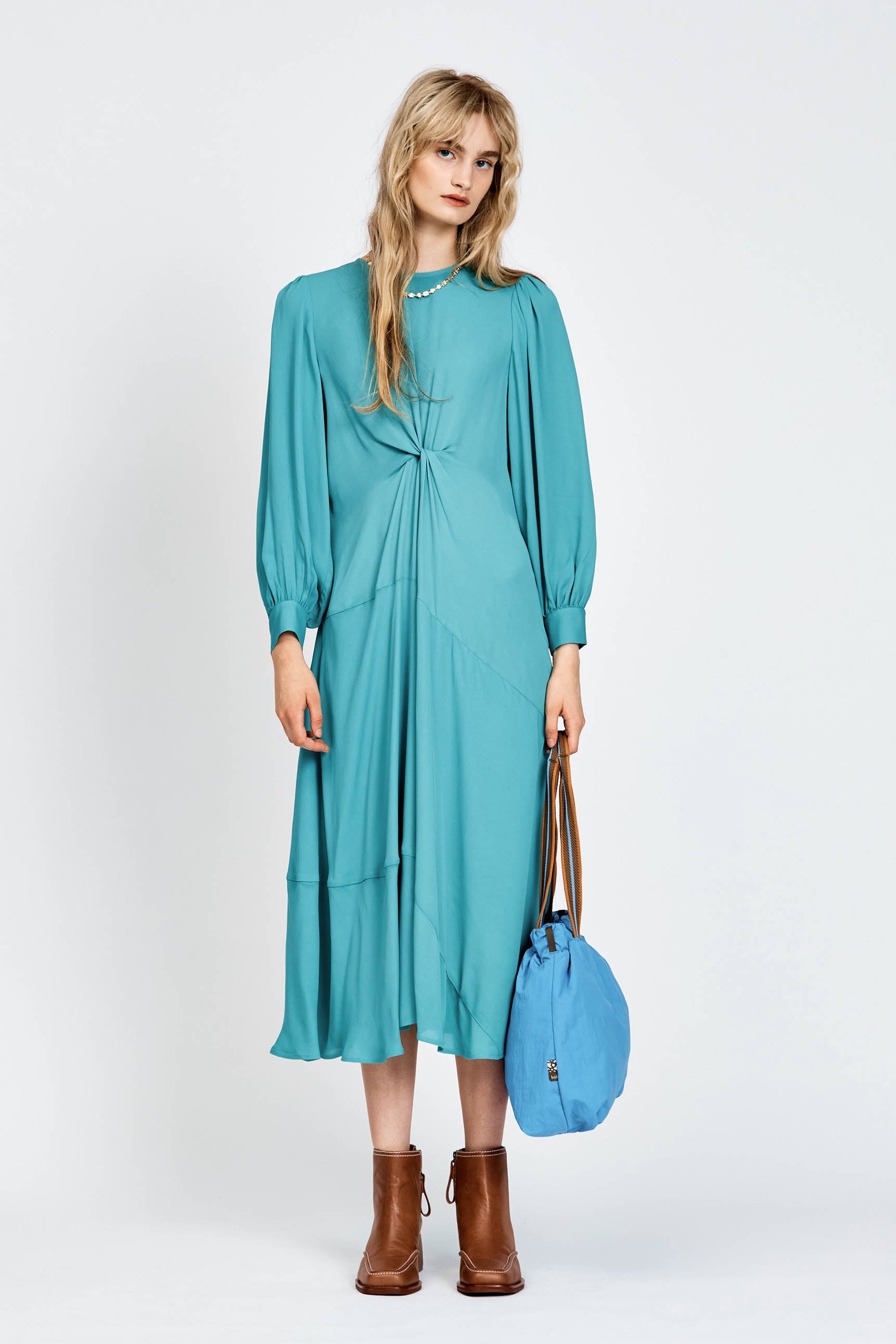 Model wearing a long sleeve green dress