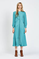 Model wearing a long sleeve green dress