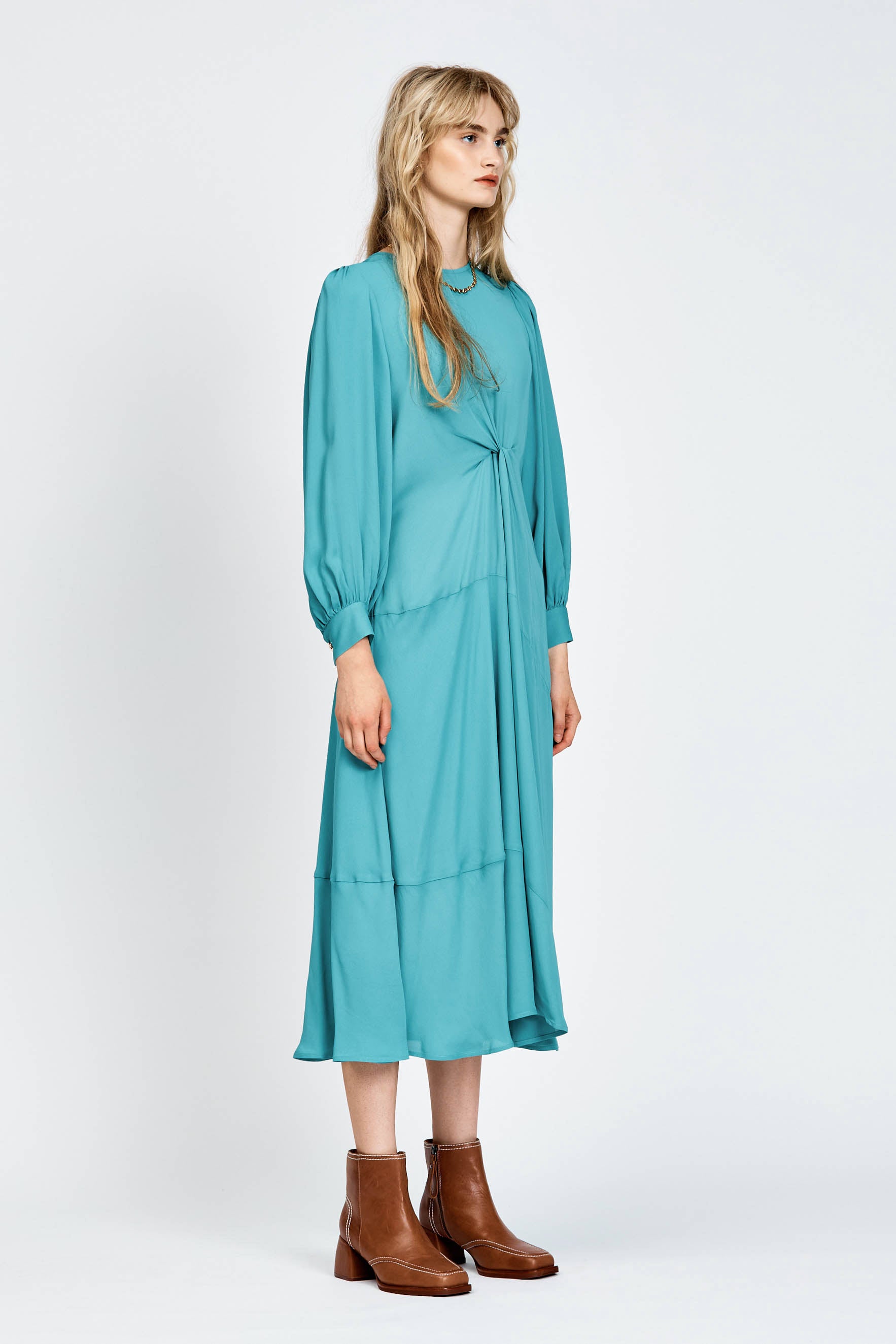 Model wearing a long sleeve green dress