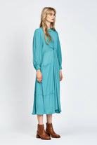 Model wearing a long sleeve green dress