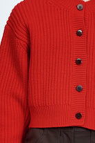 Woman wearing cable knit cardigan in red