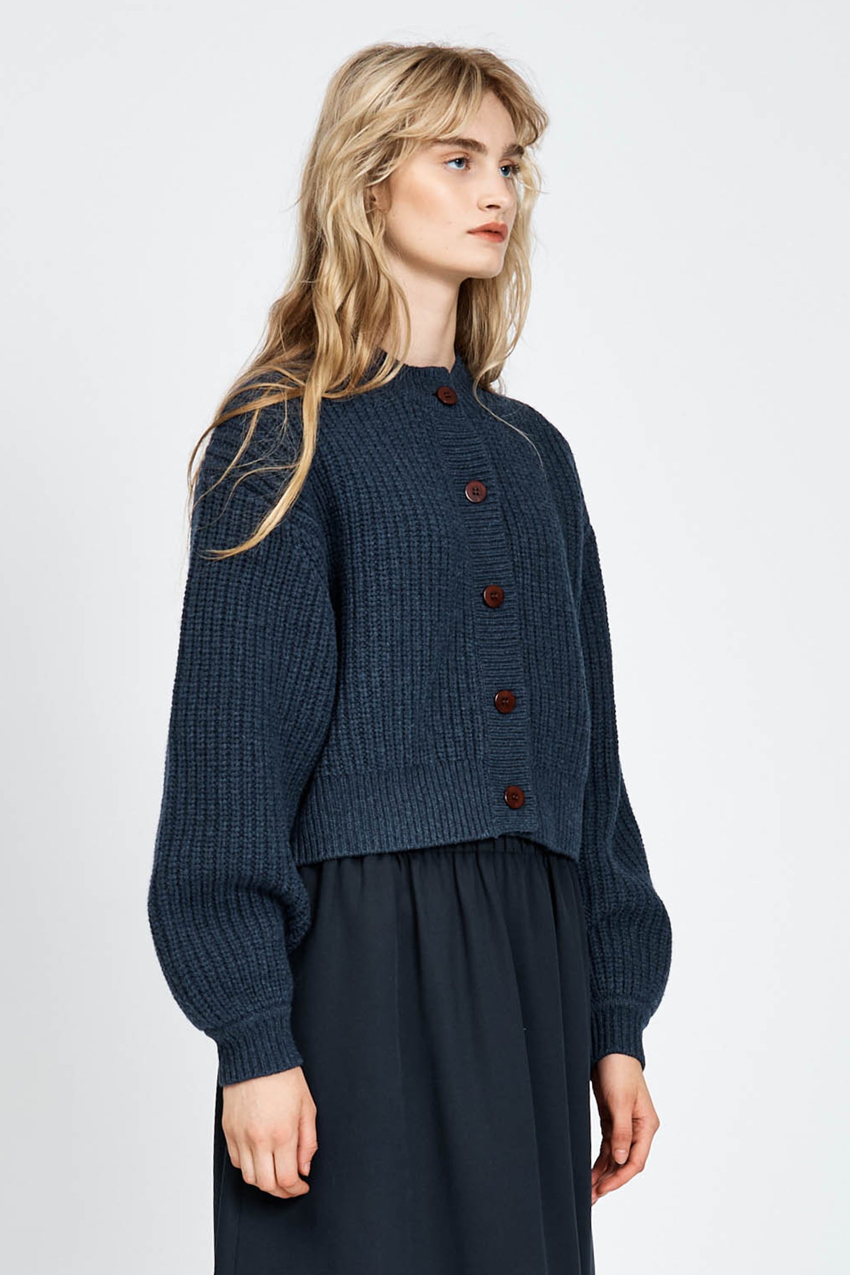 Woman wearing cable knit cardigan in navy