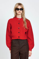 Woman wearing cable knit cardigan in red