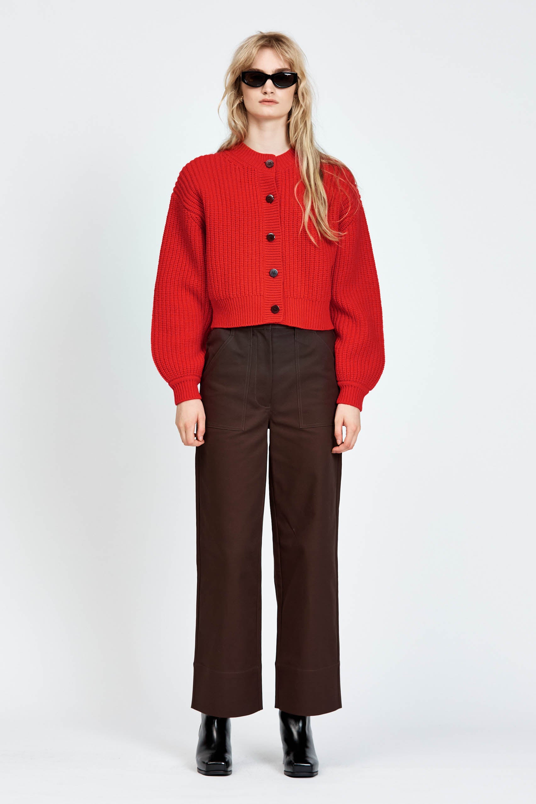 Woman wearing cable knit cardigan in red