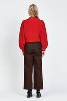 Woman wearing cable knit cardigan in red