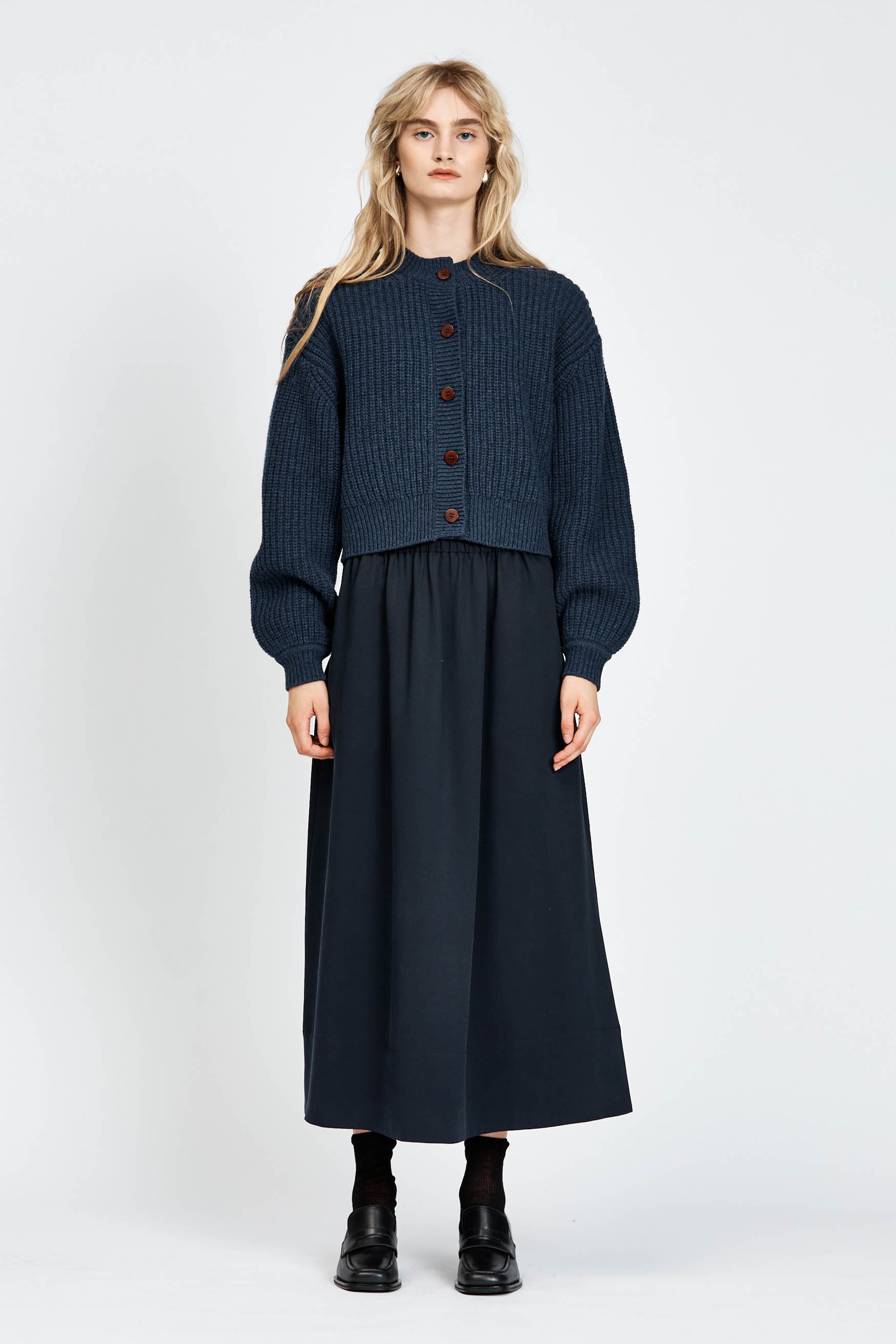 Woman wearing cable knit cardigan in navy