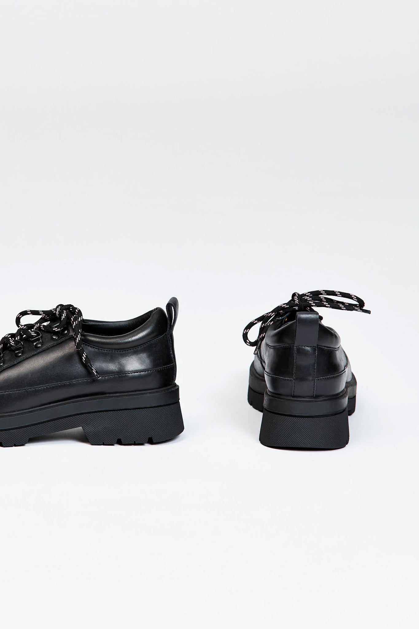 Black shoe with round toe and black and white contrast laces