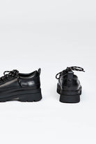 Black shoe with round toe and black and white contrast laces