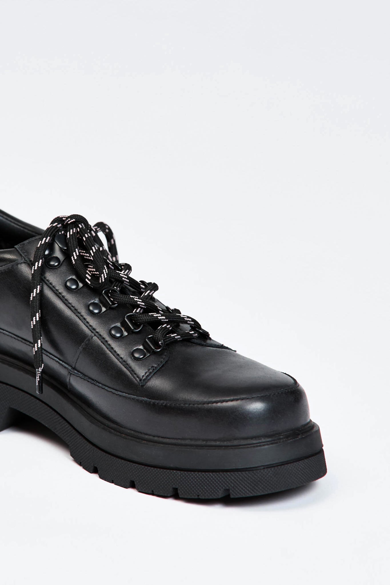 Black shoe with round toe and black and white contrast laces