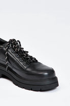 Black shoe with round toe and black and white contrast laces